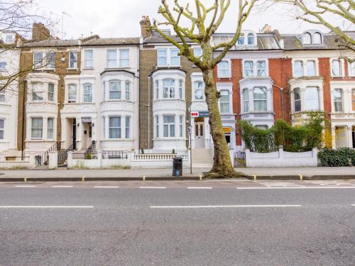 eine Reihe von Häusern auf einer Straße mit einem Baum in der Unterkunft Sino Hotel in London