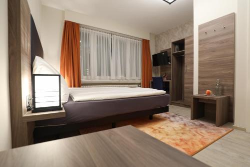 a bedroom with a bed and a window at Hotel Spatz in Luzern