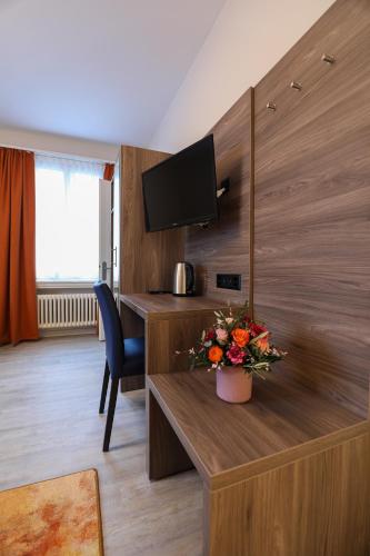 a room with a table with a vase of flowers at Hotel Spatz in Luzern