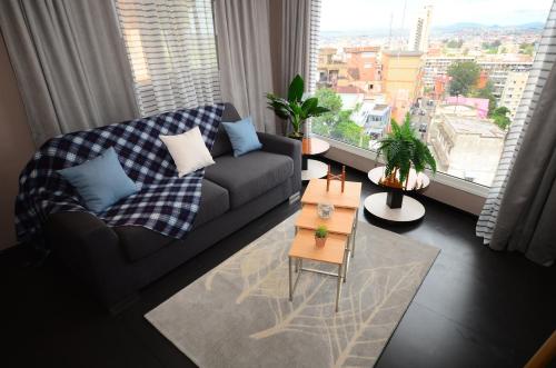 a living room with a couch and a large window at Hotel La Villette in Antananarivo