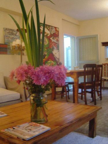a vase with purple flowers on a wooden table at Palermo Viejo Bed & Breakfast in Buenos Aires