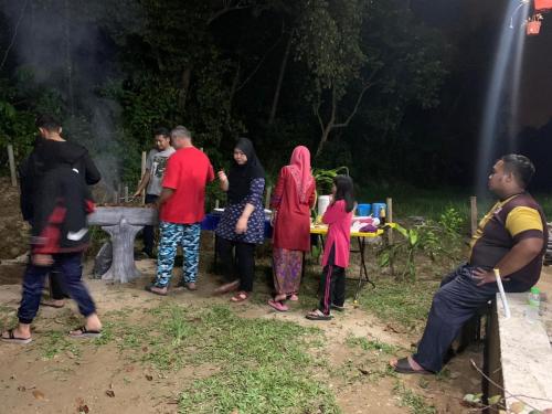 a group of people standing around a picnic table at Captain's Cabin Resort - Naval Heritage (Swimming Pool) in Kota Bharu