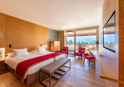 a hotel room with a large bed and a balcony at Hôtel des Bains de Saillon in Saillon