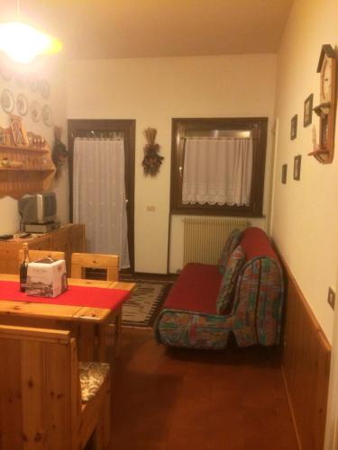 a living room with a table and a chair at Miniappartamento Dolomiti in Selva di Cadore