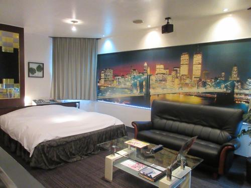 a hotel room with a bed and a couch at Ocean Hotel adult only - former Kagoshima Intelligence in Kagoshima