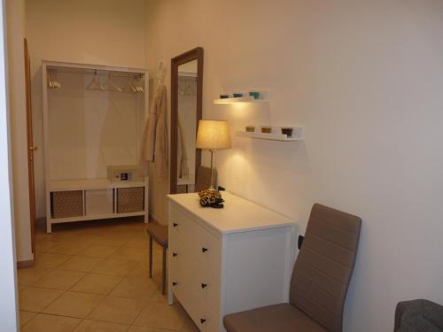ein Badezimmer mit einer Kommode, einer Lampe und einem Spiegel in der Unterkunft Hotel Villa Edda in Riccione