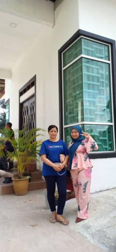 two women standing in front of a house at Captain's Cabin Resort - Naval Heritage (Swimming Pool) in Kota Bharu