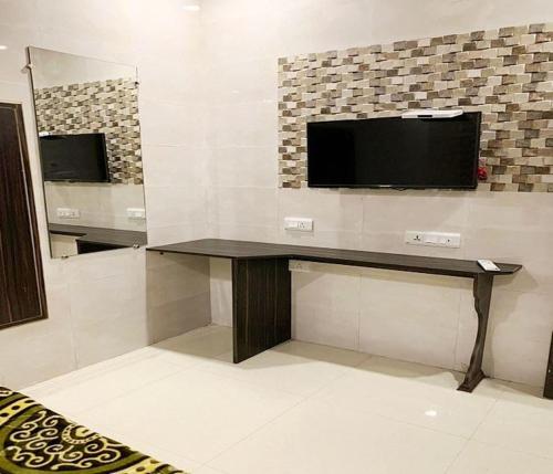 a room with a desk with a television on a wall at Hotel Star Light in Amritsar