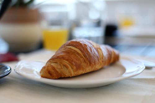 a croissant on a white plate on a table at Apartment Zanov in Preko