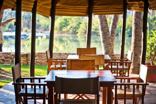 un patio con tavolo e sedie e vista sul lago di Omarunga Epupa-Falls Campsite a Epupa