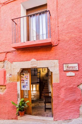 a red building with a balcony on top of it at Apartamentos Casa Samper in Santa Eulalia de Gállego