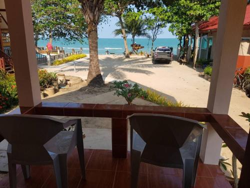 a table and chairs with a view of the beach at Phuphat Beach Resort in Khanom