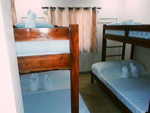 a bedroom with two bunk beds with shoes on them at Adayo Cove Resort in Siquijor