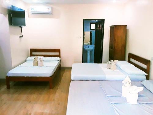 a room with two beds and a tv in it at Adayo Cove Resort in Siquijor
