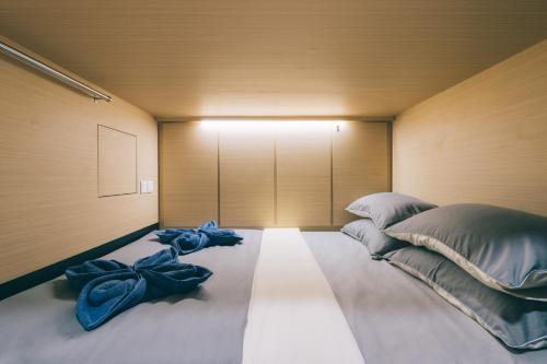 een slaapkamer met een groot bed met blauwe kussens bij Wanderloft Capsule Hostel in Singapore