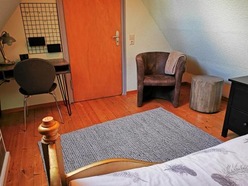 a bedroom with a bed and a chair and a desk at HR Townhouse Honigbach in Coesfeld