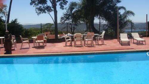 a table and chairs next to a swimming pool at Bella Vista Motel in Gosford