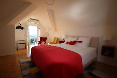 a bedroom with a large bed with a red blanket at B&B Villa Branca Barreiros AL98139 in Barreiros