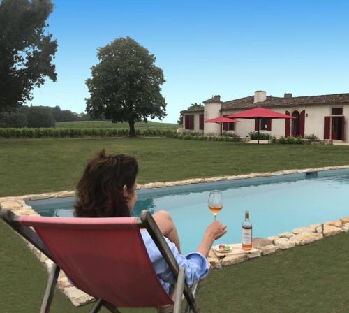 a woman sitting in a chair holding a glass of wine at Château Sigalas Rabaud in Bommes