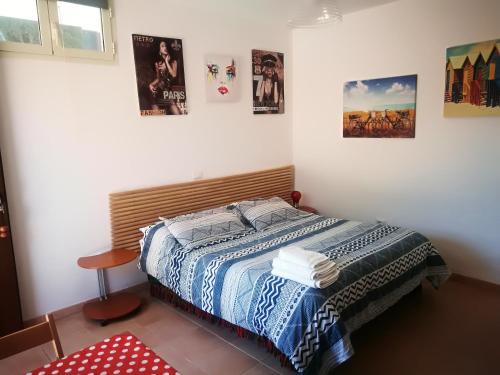 a bed in a room with posters on the wall at Edvige'S House in San Felice Circeo