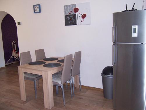 een keuken met een tafel met stoelen en een koelkast bij Salaš-dům pro společnou dovolenou až 14 osob in Salaš