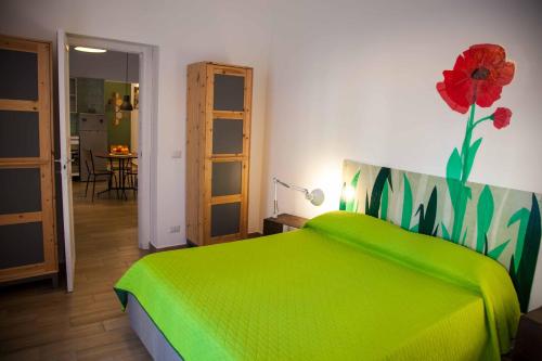 a bedroom with a green bed with a flower on the wall at Naturalliving in Catania