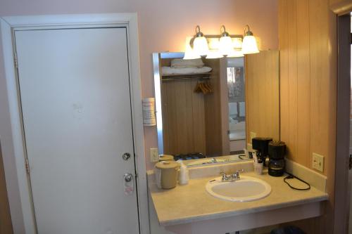 a bathroom with a sink and a mirror at Parker's Motel in Lincoln