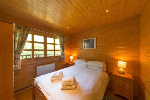 a bedroom with a bed in a wooden cabin at Cherry Log Cabin in Swanage