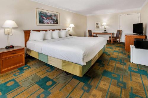 a hotel room with a large bed and a desk at La Quinta Inn by Wyndham Albuquerque Northeast in Albuquerque