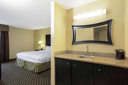 a hotel room with a bed and a sink at La Quinta by Wyndham Salina in Salina