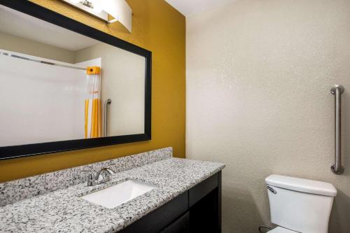 a bathroom with a sink and a toilet and a mirror at La Quinta by Wyndham Emporia in Emporia