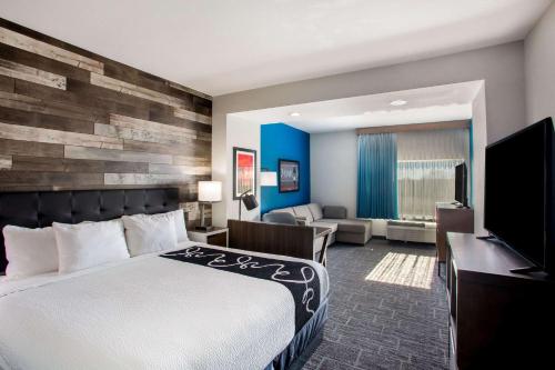 a hotel room with a bed and a television at La Quinta by Wyndham Pittsburg in Pittsburg