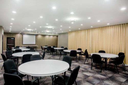 a conference room with tables and chairs and a screen at La Quinta by Wyndham Pittsburg in Pittsburg