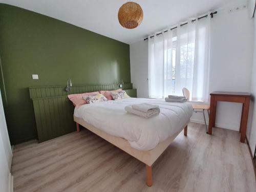 a bedroom with a large bed with green walls at GITE LES ARCHES in Saint-Andéol-le-Château