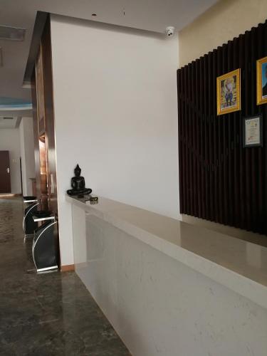 a white wall in a lobby with a counter and chairs at PACI Hotel&SPA in Sihanoukville