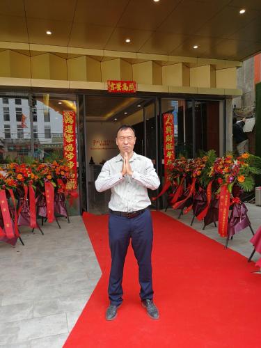 a man is standing on a red carpet with his hands at PACI Hotel&SPA in Sihanoukville
