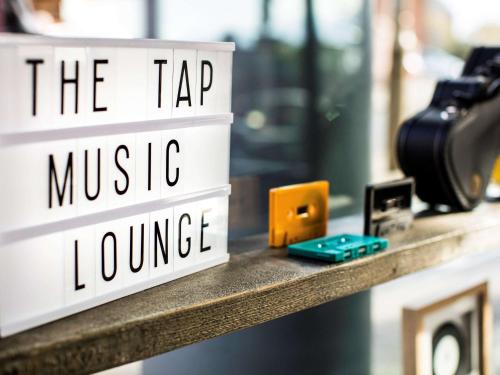 a shelf with two signs that say the tap music and lounge at Novotel Edinburgh Centre in Edinburgh