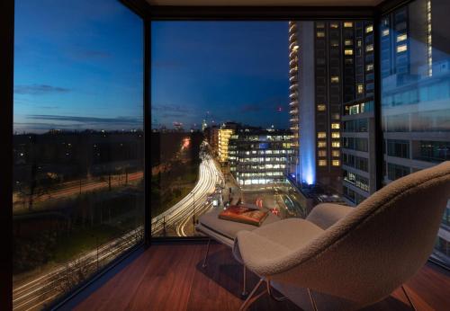 a room with two chairs and a view of a city at Four Seasons Hotel London at Park Lane in London