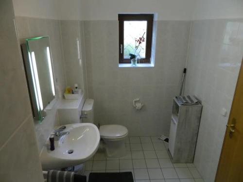 La salle de bains est pourvue d'un lavabo, de toilettes et d'une fenêtre. dans l'établissement Ferienwohnung Kiko, à Zornheim