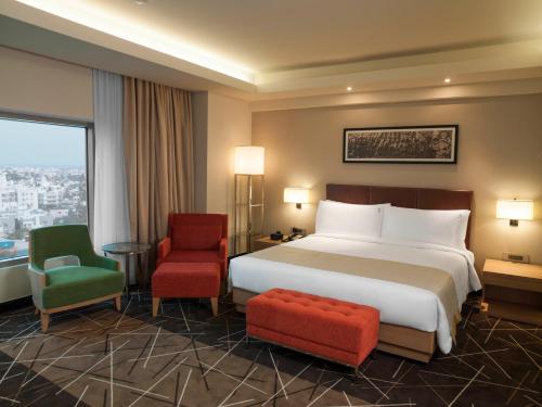 a hotel room with a bed and two chairs at Holiday Inn Chennai OMR IT Expressway by IHG in Chennai