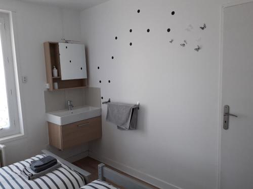 a white bathroom with a sink and a mirror at Le Corto in Savigny-Lévescault