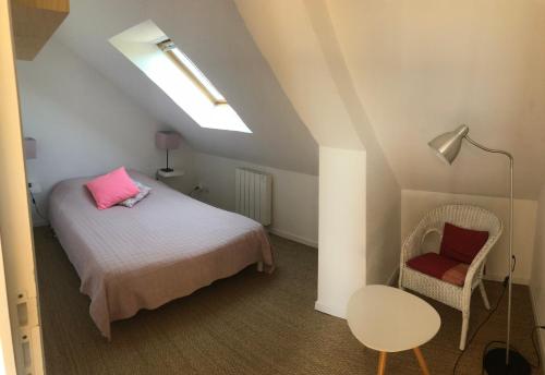 バルヌヴィル・カルトゥレにあるVilla Liludaのベッドルーム1室(ピンクの枕と椅子付きのベッド1台付)