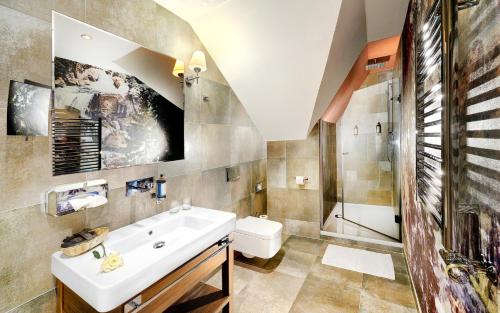 a bathroom with a sink and a shower at Grand Hotel Praha in Tatranská Lomnica