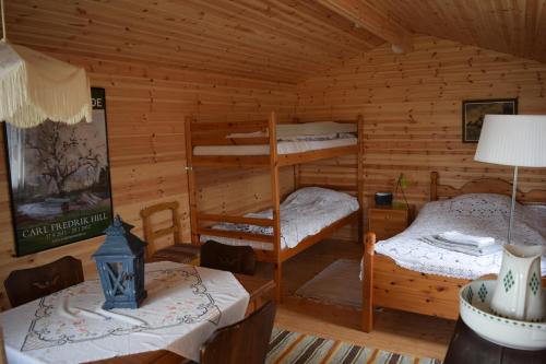 um quarto com 2 beliches num chalé de madeira em Lilla Rygårdens B&B em Lövestad