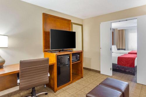 a hotel room with a desk and a tv and a bed at Comfort Suites Oakbrook Terrace near Oakbrook Center in Oakbrook Terrace
