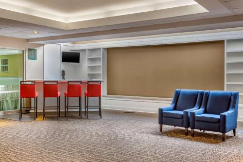 a room with a bar and chairs and a screen at Comfort Suites Oakbrook Terrace near Oakbrook Center in Oakbrook Terrace