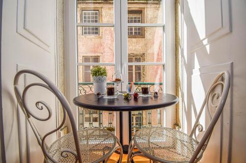 a table and chairs in front of a window at B in B Lisbon Downtown Suites in Lisbon
