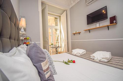 a bedroom with a bed with a tv on the wall at B in B Lisbon Downtown Suites in Lisbon