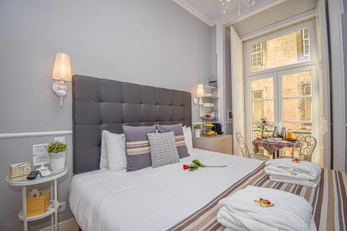 una camera da letto con un grande letto con fiori di B in B Lisbon Downtown Suites a Lisbona
