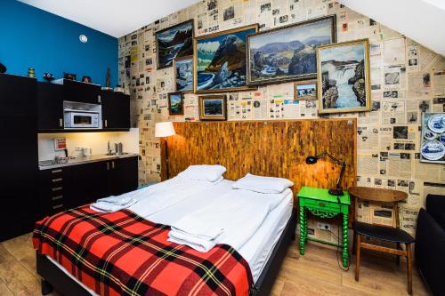 a bedroom with a bed and a wall covered in pictures at OK Studios in Reykjavík